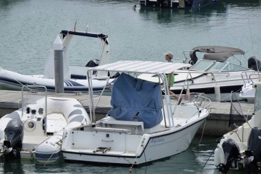 İtalya, Sicilya, Akdeniz, Marina di Ragusa; 5 Ağustos 2018, Genç bir çocuk ve motorlu tekneler limanda - Editörden