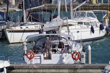 İtalya, Sicilya, Akdeniz, Marina di Ragusa; 25 Ağustos 2018, adam onun Yelkenli tekne Port - yazı işleri