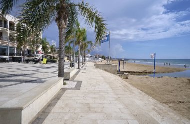 İtalya, Sicilya, Akdeniz, Marina di Ragusa (Ragusa eyaletinde); 12 Ekim 2018, palmiye ağaçları - yazı işleri ile deniz görünümü