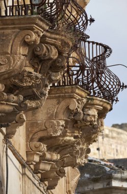 İtalya, Sicilya, Scicli (Ragusa eyaletinde), Barok binada Mormino Penna Street, altında bir balkon süs heykeller