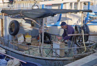 İtalya, Sicilya, Akdeniz, Marina di Ragusa; 20 Aralık 2018, onun ağlar Port - editoryal bir balıkçı teknesinde temizlik balıkçı 