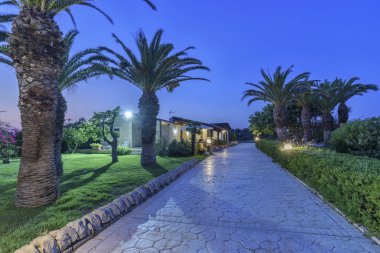 İtalya, Sicilya, Sampieri (Ragusa eyaletinde), kırsal; 10 Ağustos 2018, ev ve Bahçe taş günbatımında - Editörden