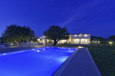 İtalya, Sicilya, Santacroce Camerina (Ragusa eyaletinde), kırsal; 8 Mayıs 2018, Bahçe ve yüzme havuzu ev günbatımı - yazı işleri