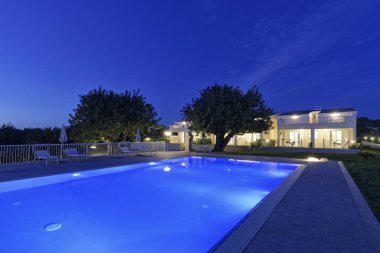 İtalya, Sicilya, Santacroce Camerina (Ragusa eyaletinde), kırsal; 8 Mayıs 2018, Bahçe ve yüzme havuzu ev günbatımı - yazı işleri