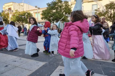 İtalya, Sicilya, Marina di Ragusa (Ragusa eyaletinde); 2 Mart 2019, karnaval için şehrin - editoryal merkezi kare oynayan çocuklar