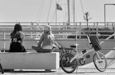 İtalya, Sicilya, Marina di Ragusa; 8 Mart 2019, kız Bisikletleri Port - yazı işleri ile bir bankta