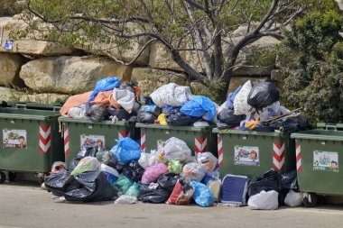 İtalya, Sicilya, Marina di Ragusa (Ragusa Eyaleti); 25 Nisan 2019, bir sokakta tam çöp konteynerleri - Editörden
