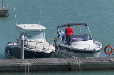 İtalya, Sicilya, Akdeniz, Marina di Ragusa; 10 Mayıs 2019, limanda insanlar ve motorlu tekneler - Editörden