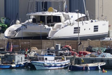 İtalya, Sicilya, Akdeniz, Marina di Ragusa; 24 Mayıs 2019, limanda ahşap balıkçı tekneleri ve lüks yatlar - Editörden