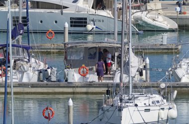 İtalya, Sicilya, Akdeniz, Marina di Ragusa; 31 Mayıs 2019' da limanda insanlar ve lüks yatlar - Editörden