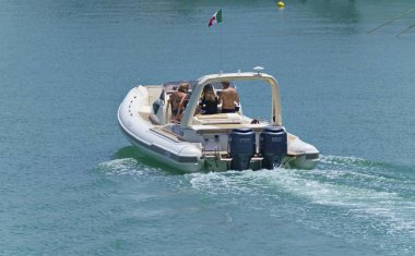 İtalya, Sicilya, Akdeniz, Marina di Ragusa (Ragusa eyaleti); 9 Haziran 2019, limanda bir lastik teknede insanlar-editoryal