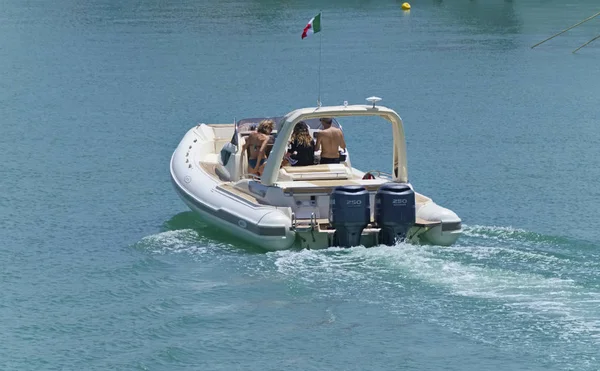 İtalya, Sicilya, Akdeniz, Marina di Ragusa (Ragusa eyaleti); 9 Haziran 2019, limanda bir lastik teknede insanlar-editoryal