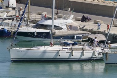 İtalya, Sicilya, Akdeniz, Marina di Ragusa (Ragusa eyaleti); 9 Haziran 2019, limanda bir yelkenli teknede insanlar-editoryal