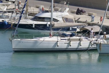 İtalya, Sicilya, Akdeniz, Marina di Ragusa (Ragusa eyaleti); 9 Haziran 2019, limanda bir yelkenli teknede insanlar-editoryal