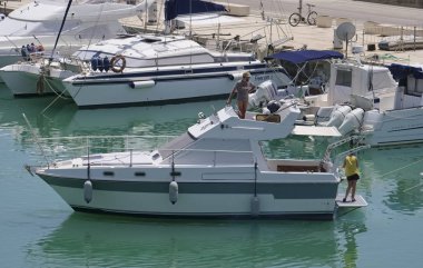 İtalya, Sicilya, Akdeniz, Marina di Ragusa (Ragusa eyaleti); 11 Haziran 2019, limanda lüks yatta insanlar-editoryal