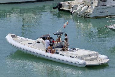 İtalya, Sicilya, Akdeniz, Marina di Ragusa (Ragusa Eyaleti); 16 Haziran 2019, limanda büyük bir lastik teknede insanlar - Editörden