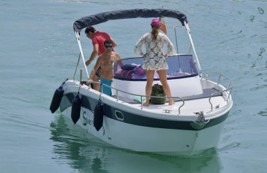 İtalya, Sicilya, Akdeniz, Marina di Ragusa (Ragusa Eyaleti); 16 Haziran 2019, limanda bir motorlu teknede insanlar - Editörden