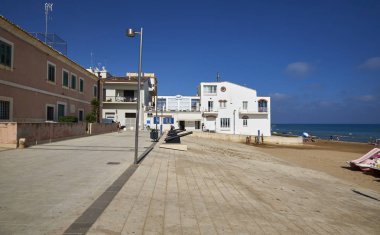 İtalya, Sicilya, Akdeniz, Marina di Ragusa (Ragusa Eyaleti); 19 Haziran 2019, sahilde eski toplar ve sahilde insanlar - Editörden