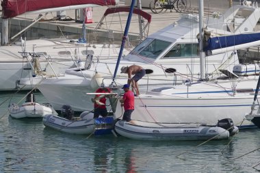 İtalya, Sicilya, Akdeniz, Marina di Ragusa (Ragusa Eyaleti); 23 Haziran 2019, limanda insanlar ve lüks yatlar - Editörden