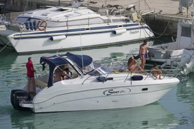 taly, Sicilya, Akdeniz, Marina di Ragusa (Ragusa Eyaleti); 23 Haziran 2019, limanda bir motorlu teknede insanlar - Editörden