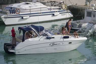 taly, Sicilya, Akdeniz, Marina di Ragusa (Ragusa Eyaleti); 23 Haziran 2019, limanda bir motorlu teknede insanlar - Editörden