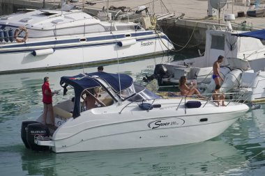 taly, Sicilya, Akdeniz, Marina di Ragusa (Ragusa Eyaleti); 23 Haziran 2019, limanda bir motorlu teknede insanlar - Editörden