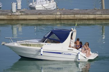 İtalya, Sicilya, Akdeniz, Marina di Ragusa (Ragusa Eyaleti); 23 Haziran 2019, limanda bir motorlu teknede insanlar - Editörden