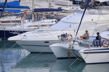 İtalya, Sicilya, Akdeniz, Marina di Ragusa (Ragusa Eyaleti); 27 Haziran 2019, limanda bir yelkenli teknede insanlar - Editörden