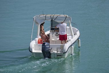 İtalya, Sicilya, Akdeniz, Marina di Ragusa (Ragusa Eyaleti); 14 Temmuz 2019, limanda bir motorlu teknede insanlar - Editörden