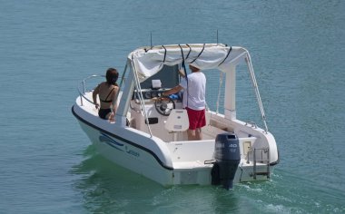 İtalya, Sicilya, Akdeniz, Marina di Ragusa (Ragusa Eyaleti); 14 Temmuz 2019, limanda bir motorlu teknede insanlar - Editörden