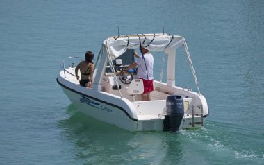 İtalya, Sicilya, Akdeniz, Marina di Ragusa (Ragusa Eyaleti); 14 Temmuz 2019, limanda bir motorlu teknede insanlar - Editörden