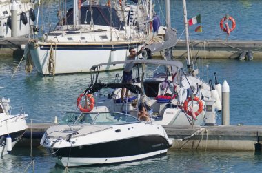İtalya, Sicilya, Akdeniz, Marina di Ragusa (Ragusa Eyaleti); 18 Temmuz 2019'da limanda insanlar, motorlu tekneler ve lüks yatlar - Editörden Haberler