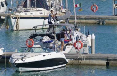 İtalya, Sicilya, Akdeniz, Marina di Ragusa (Ragusa Eyaleti); 18 Temmuz 2019'da limanda insanlar, motorlu tekneler ve lüks yatlar - Editörden Haberler