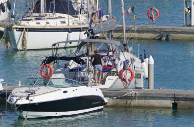 İtalya, Sicilya, Akdeniz, Marina di Ragusa (Ragusa Eyaleti); 18 Temmuz 2019'da limanda insanlar, motorlu tekneler ve lüks yatlar - Editörden Haberler