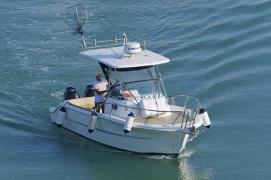 İtalya, Sicilya, Akdeniz, Marina di Ragusa (Ragusa Eyaleti); 19 Temmuz 2019, limanda bir motorlu teknede adam - Editörden