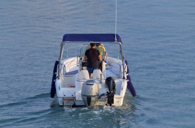 İtalya, Sicilya, Akdeniz, Marina di Ragusa (Ragusa Eyaleti); 20 Temmuz 2019, limanda bir motorlu teknede insanlar - Editörden