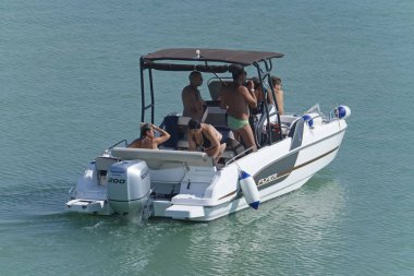 İtalya, Sicilya, Akdeniz, Marina di Ragusa (Ragusa eyaleti); 25 Temmuz 2019, limanda bir motorlu teknede insanlar-editoryal