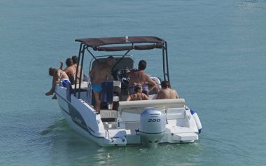 İtalya, Sicilya, Akdeniz, Marina di Ragusa (Ragusa eyaleti); 25 Temmuz 2019, limanda bir motorlu teknede insanlar-editoryal