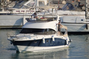 İtalya, Sicilya, Akdeniz, Marina di Ragusa (Ragusa eyaleti); 25 Temmuz 2019, limanda lüks yatta insanlar-editoryal