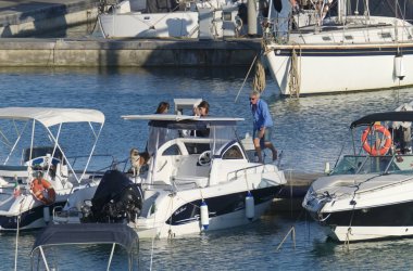 İtalya, Sicilya, Akdeniz, Marina di Ragusa (Ragusa Eyaleti); 30 Temmuz 2019, limanda insanlar, motorlu tekneler ve lüks yatlar - Editörden Haberler