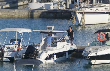 İtalya, Sicilya, Akdeniz, Marina di Ragusa (Ragusa Eyaleti); 30 Temmuz 2019, limanda insanlar, motorlu tekneler ve lüks yatlar - Editörden Haberler