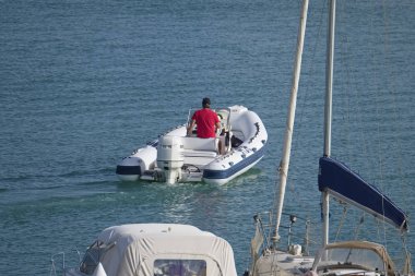 İtalya, Sicilya, Akdeniz, Marina di Ragusa (Ragusa Eyaleti); 2 Ağustos 2019, limanda lastik botta insanlar - Editörden