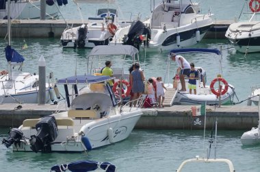 İtalya, Sicilya, Akdeniz, Marina di Ragusa (Ragusa Eyaleti); 3 Ağustos 2019' da limanda insanlar, motorlu tekneler ve lüks yatlar - Editörden