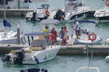 İtalya, Sicilya, Akdeniz, Marina di Ragusa (Ragusa Eyaleti); 3 Ağustos 2019' da limanda insanlar, motorlu tekneler ve lüks yatlar - Editörden