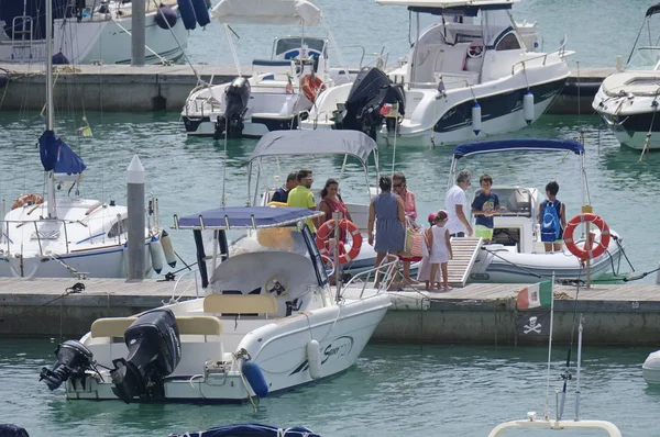İtalya, Sicilya, Akdeniz, Marina di Ragusa (Ragusa Eyaleti); 3 Ağustos 2019' da limanda insanlar, motorlu tekneler ve lüks yatlar - Editörden