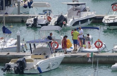 İtalya, Sicilya, Akdeniz, Marina di Ragusa (Ragusa Eyaleti); 3 Ağustos 2019' da limanda insanlar, motorlu tekneler ve lüks yatlar - Editörden