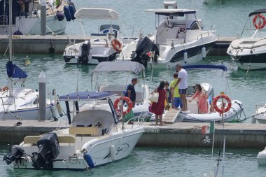 İtalya, Sicilya, Akdeniz, Marina di Ragusa (Ragusa Eyaleti); 3 Ağustos 2019' da limanda insanlar, motorlu tekneler ve lüks yatlar - Editörden