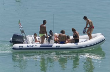 İtalya, Sicilya, Akdeniz, Marina di Ragusa (Ragusa Eyaleti); 4 Ağustos 2019, limanda lastik botta insanlar - Editörden