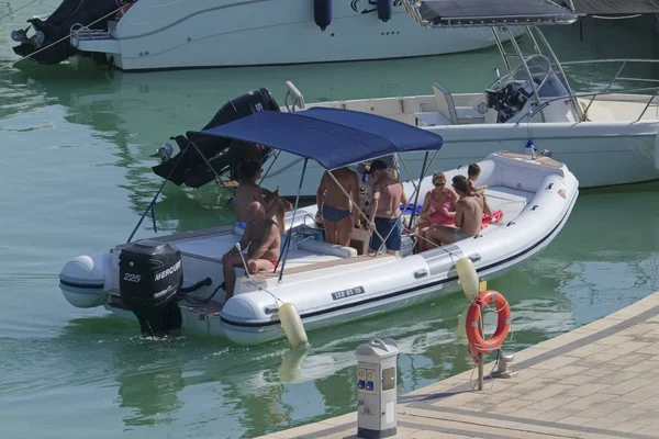 İtalya, Sicilya, Akdeniz, Marina di Ragusa (Ragusa Eyaleti); 4 Ağustos 2019, limanda lastik botta insanlar - Editörden