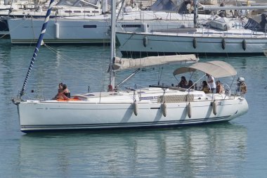 İtalya, Sicilya, Akdeniz, Marina di Ragusa (Ragusa Eyaleti); 4 Ağustos 2019, limanda bir yelkenli teknede insanlar - Editörden